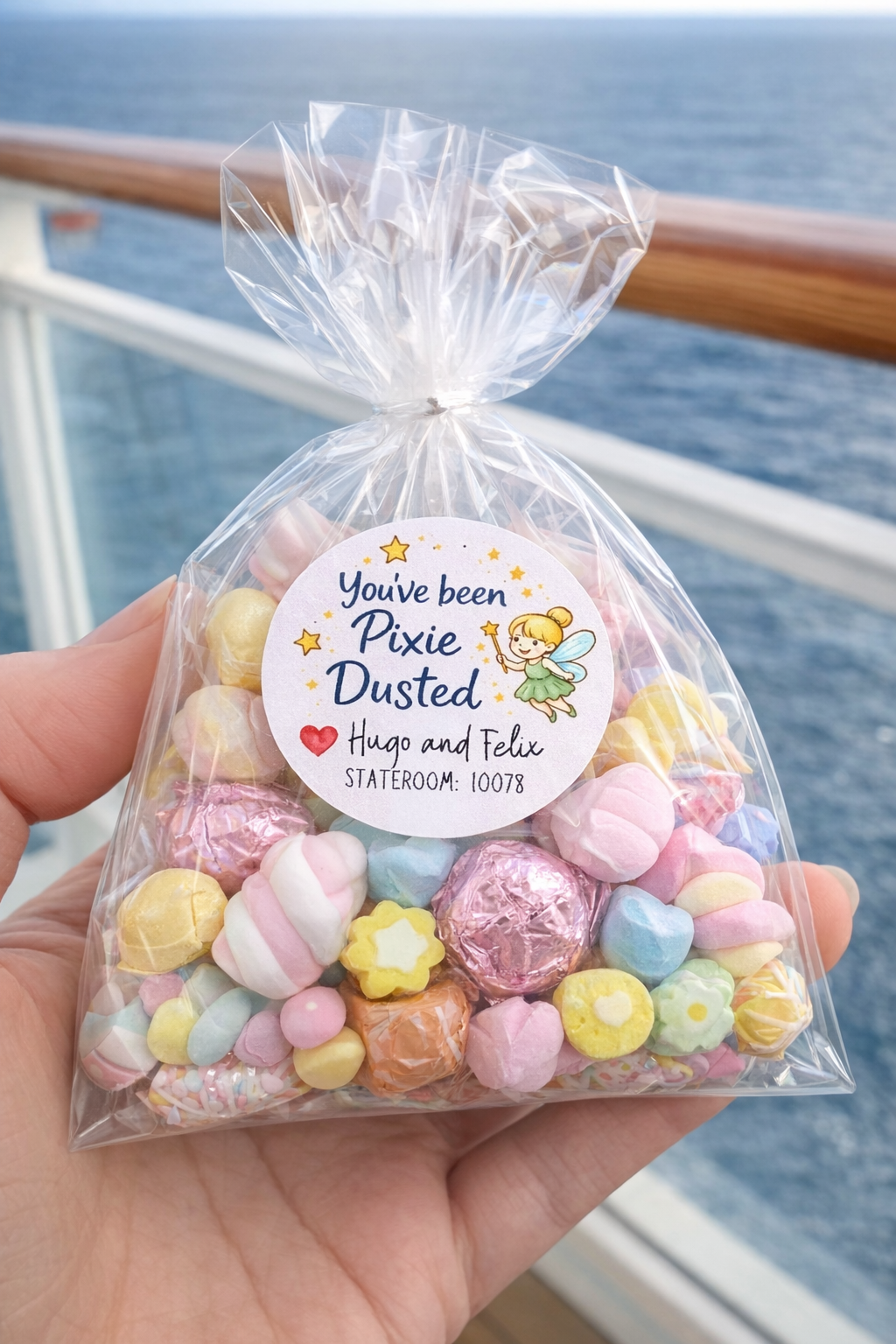 Personalized pixie dust cruise sticker on clear gift bag with pastel candy for cabin door surprise and cruise fish extender gift